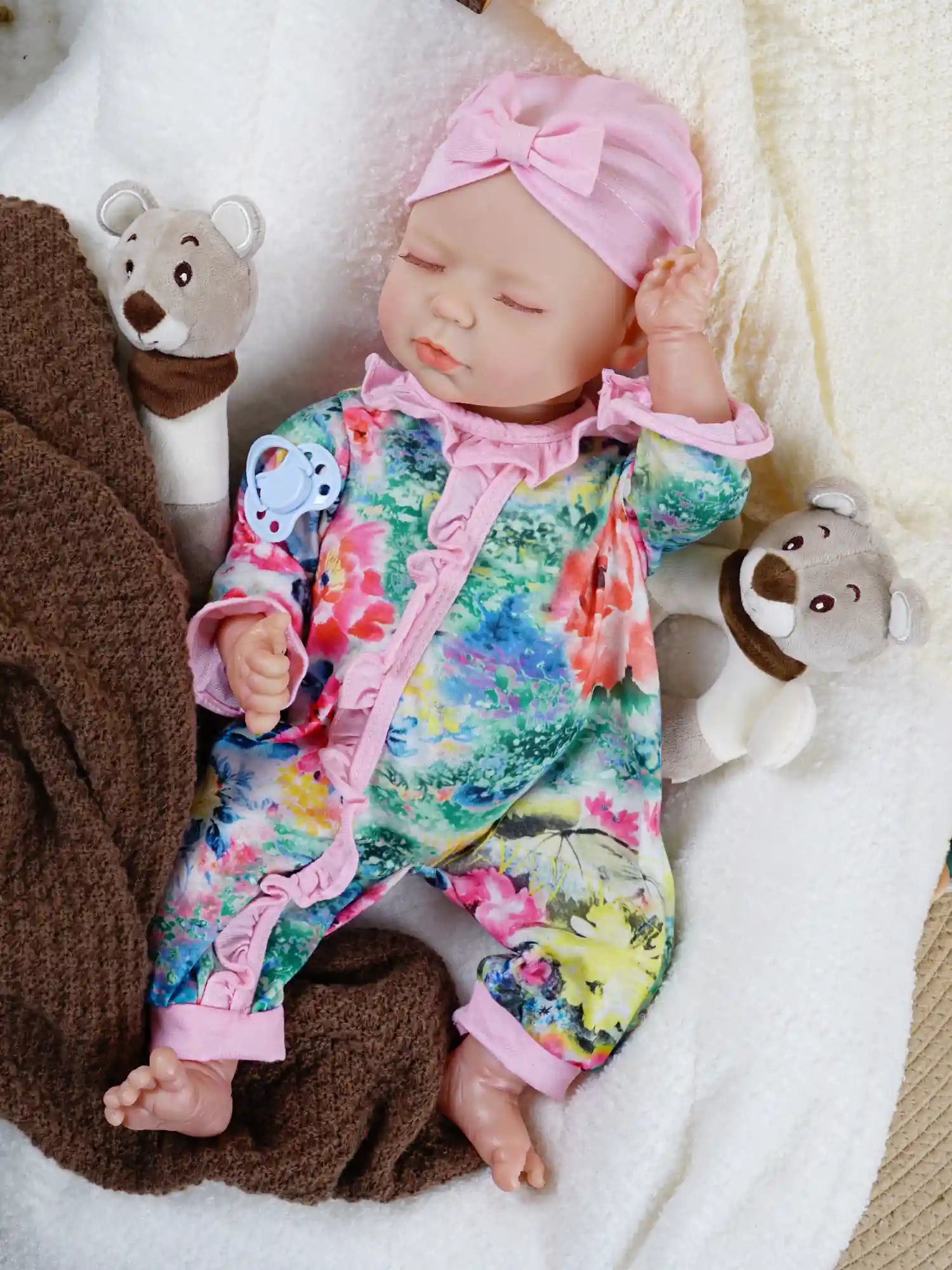 Colorful floral jumpsuit on lifelike reborn baby doll.