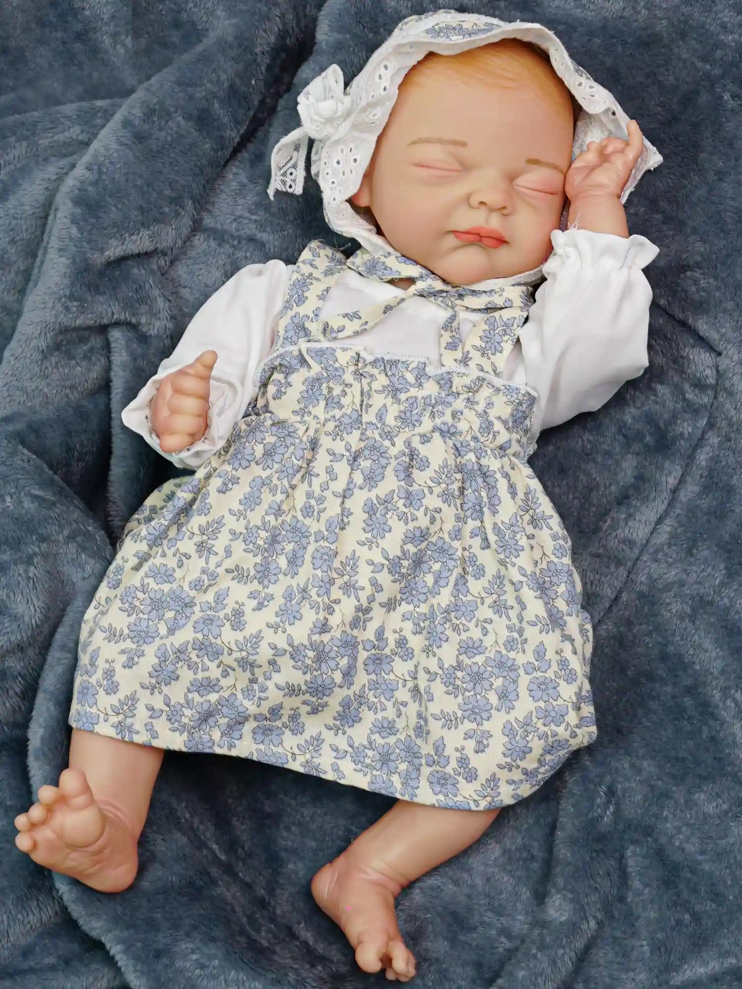 Another close-up of the first baby doll, where she appears to be in a deep sleep, her head adorned with the pink headband, and the colorful jumpsuit visible.