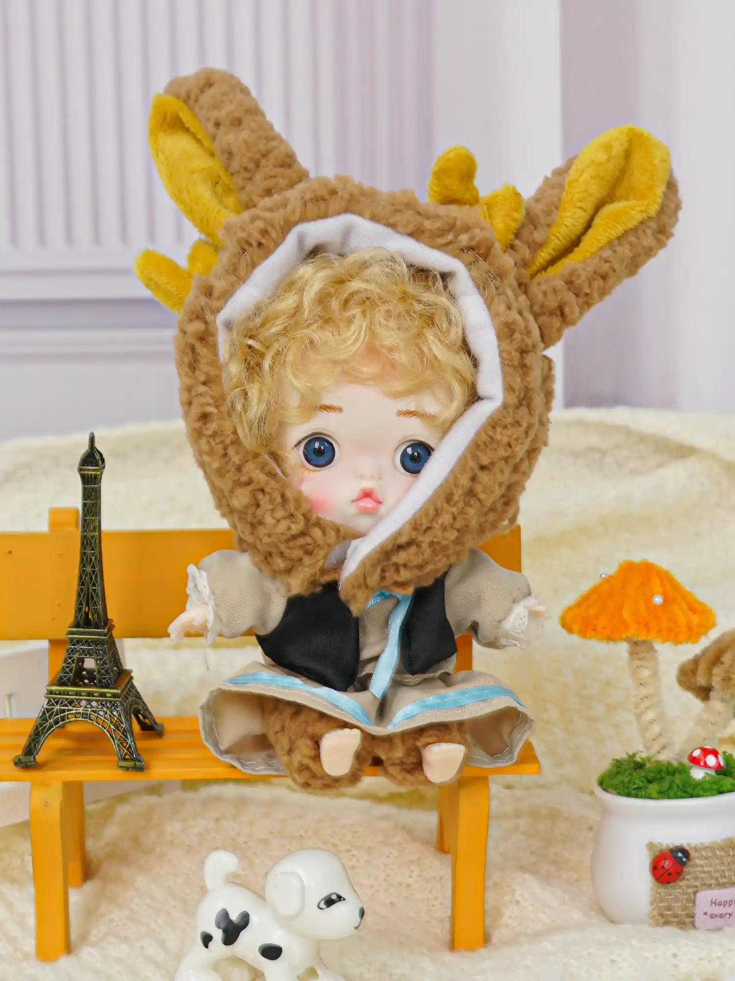 A fantasy scene with a doll in a bunny outfit, complete with a toy Eiffel Tower and a white puppy figurine.