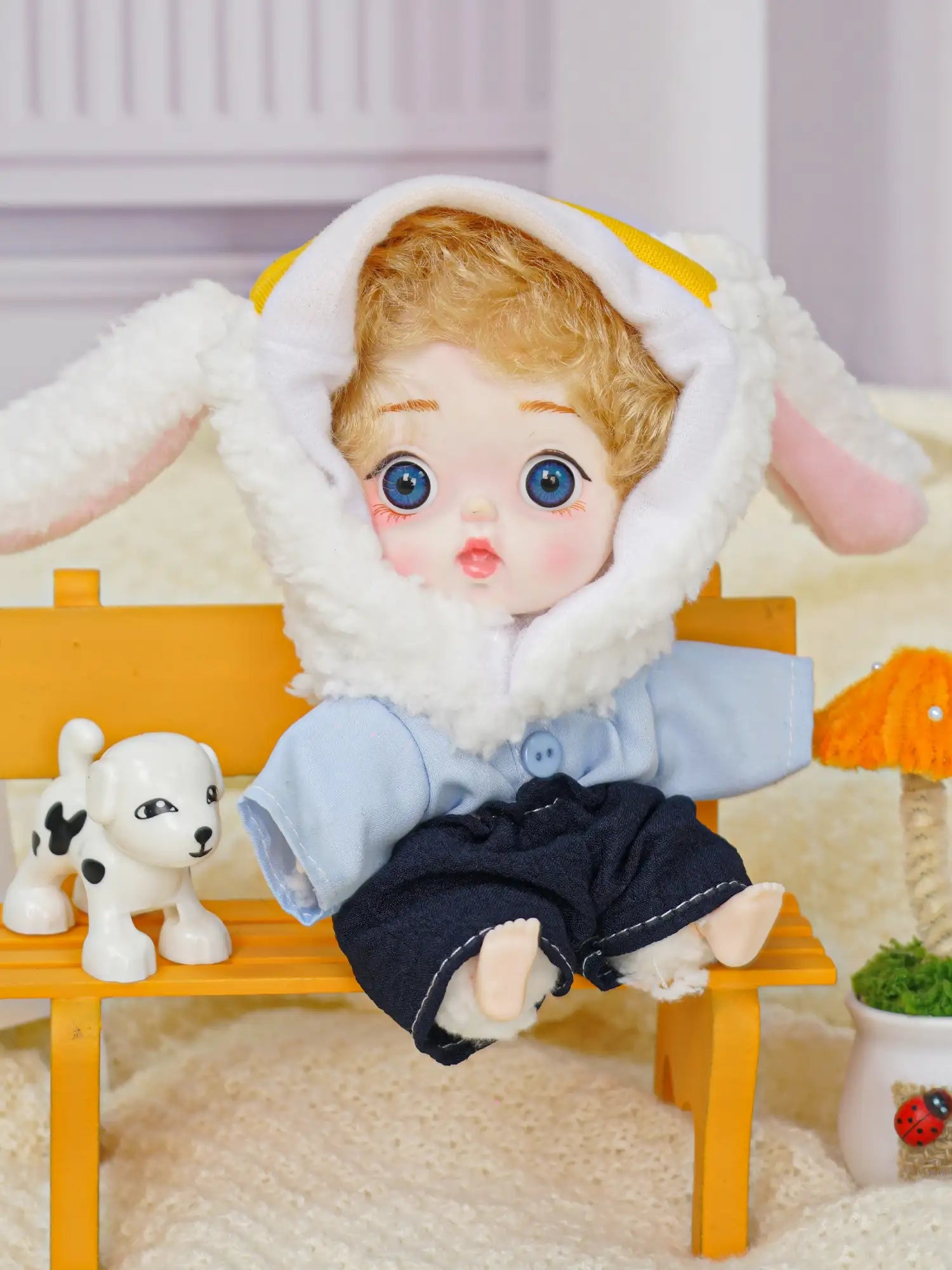 An endearing doll with a sheep-themed hat and a curious gaze, alongside a playful puppy toy and small decorations.