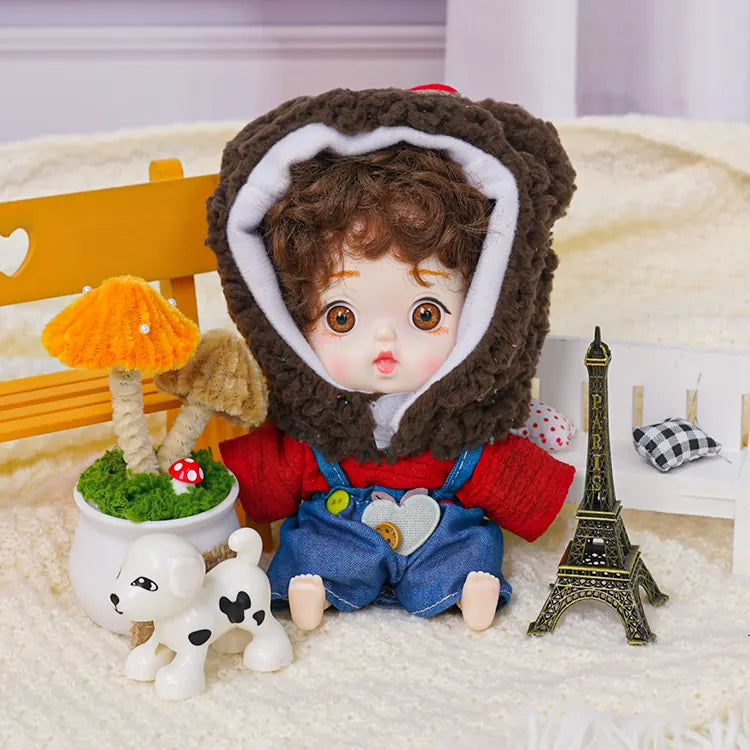 A playful doll in a brown bear cap, with a small Eiffel Tower and a toy dog adding charm to the scene.
