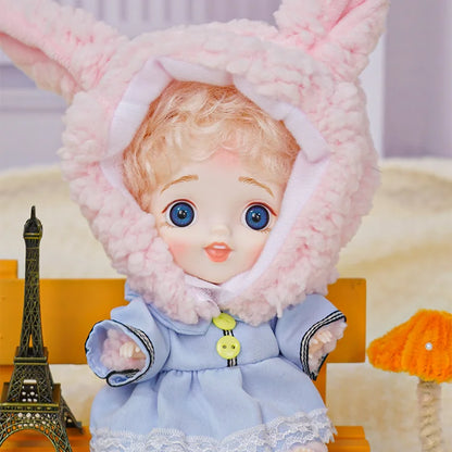 BJD with curly hair, blue eyes, bunny ears, and playful companions.