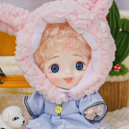 BJD with blue eyes in a rabbit costume alongside a white dog figurine.