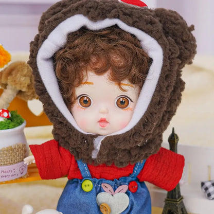 A delightful doll with a whimsical bear hat and denim overalls, accompanied by a little Eiffel Tower and a toy dog.