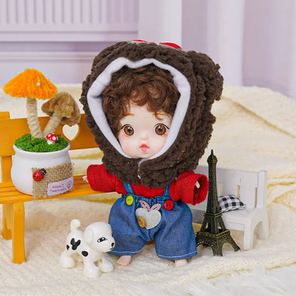 An adorable doll in a bear costume with a whimsical backdrop including a toy Eiffel Tower and playful puppy figure.