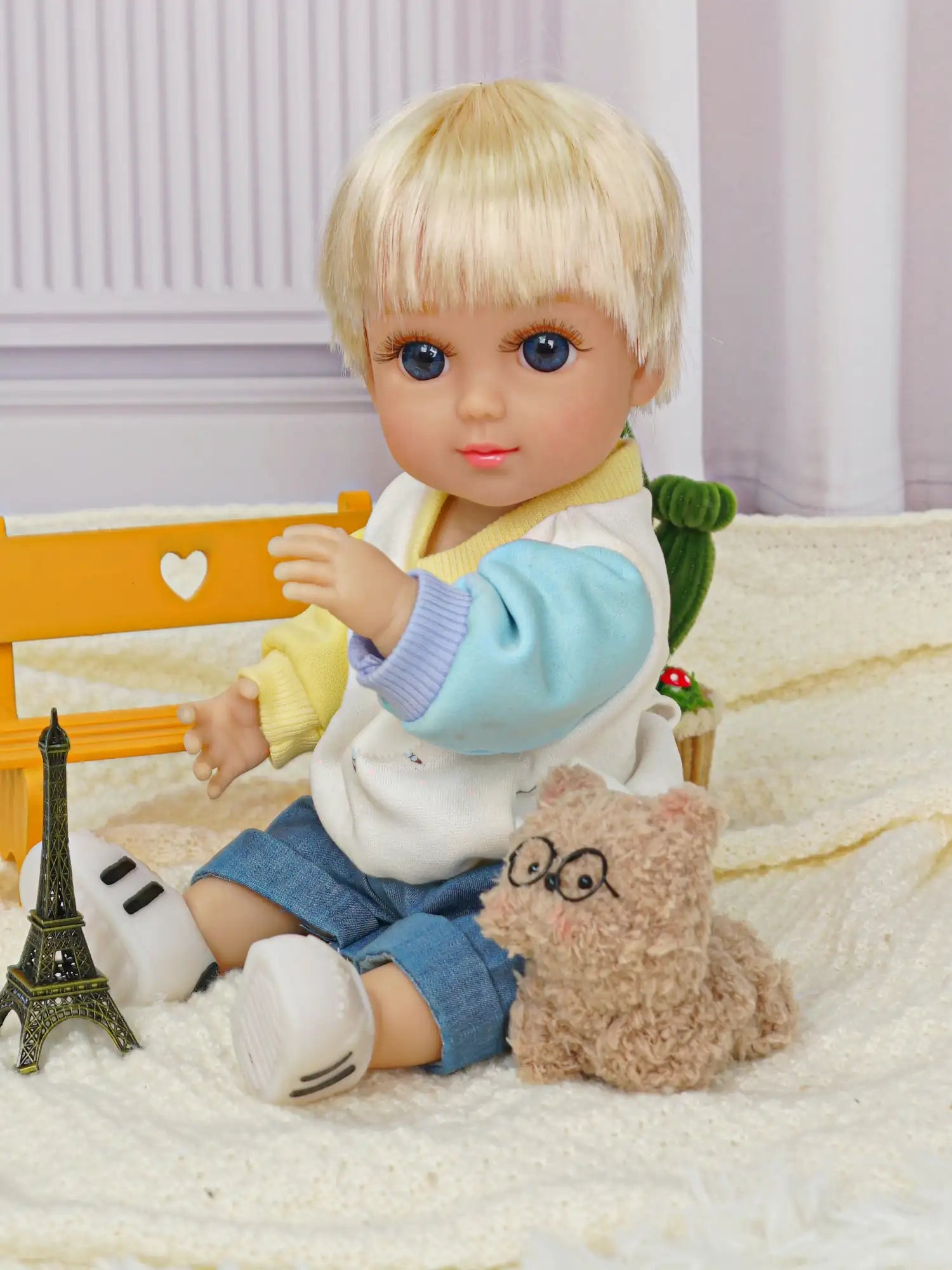 Charming blonde doll with a bob cut, dressed in a cozy sweater and shorts, with whimsical toys.