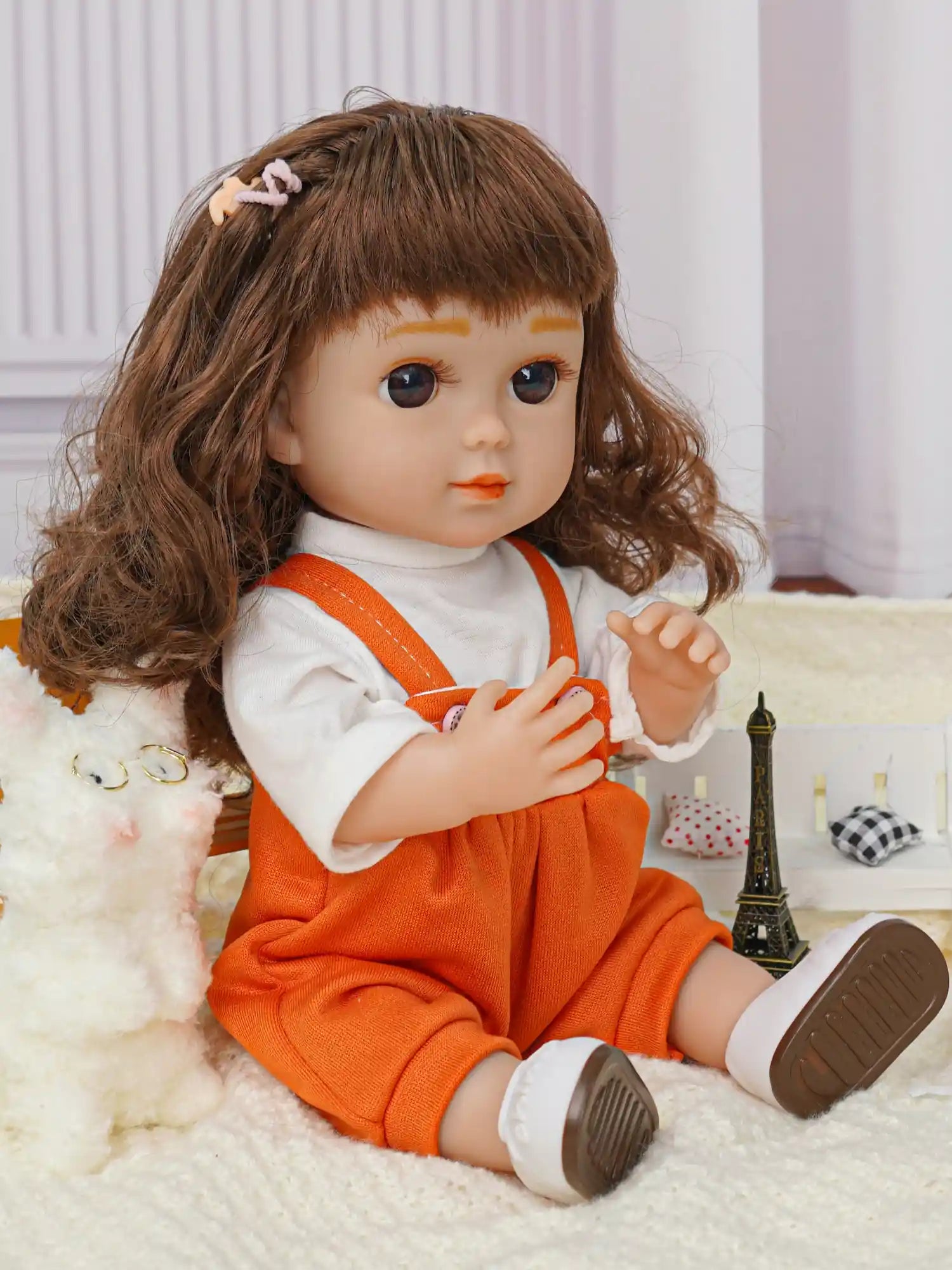 Toy doll in vibrant orange attire seated beside a white fluffy dog with spectacles.