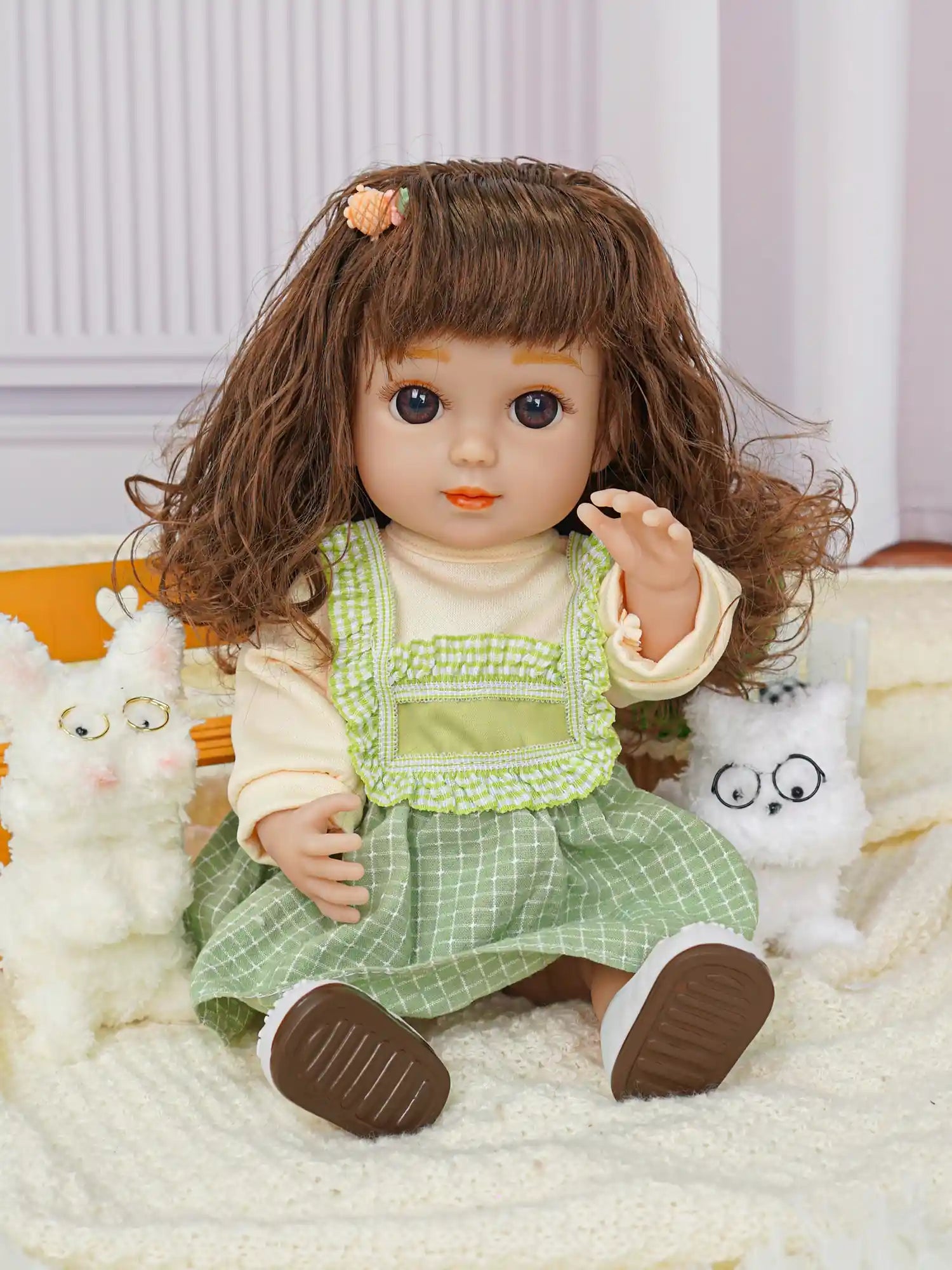 Smiling doll seated with a pair of white fluffy toy dogs and a toy cactus.