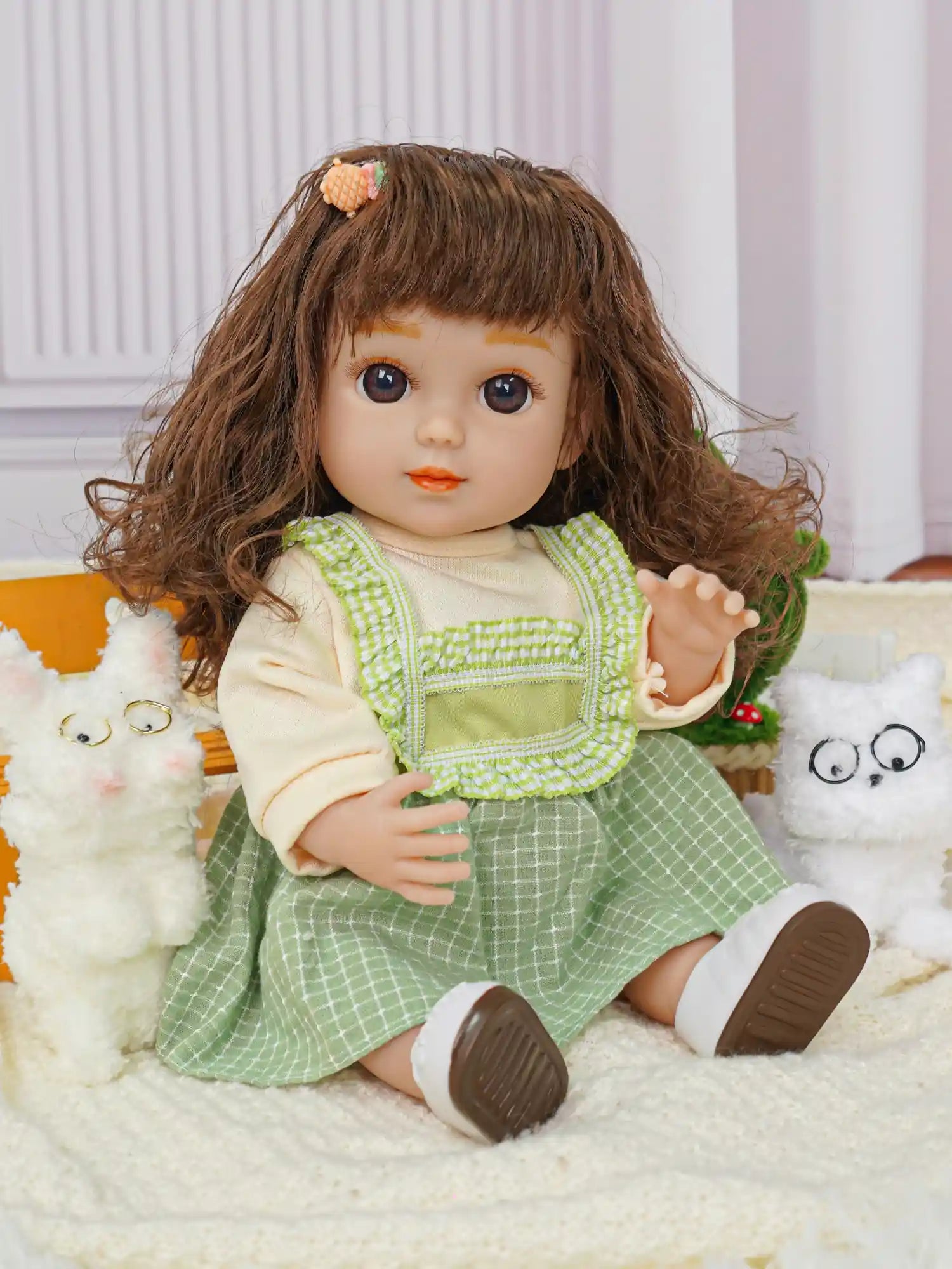 Doll waving in a layered outfit, with two fluffy dog toys and a green plant.