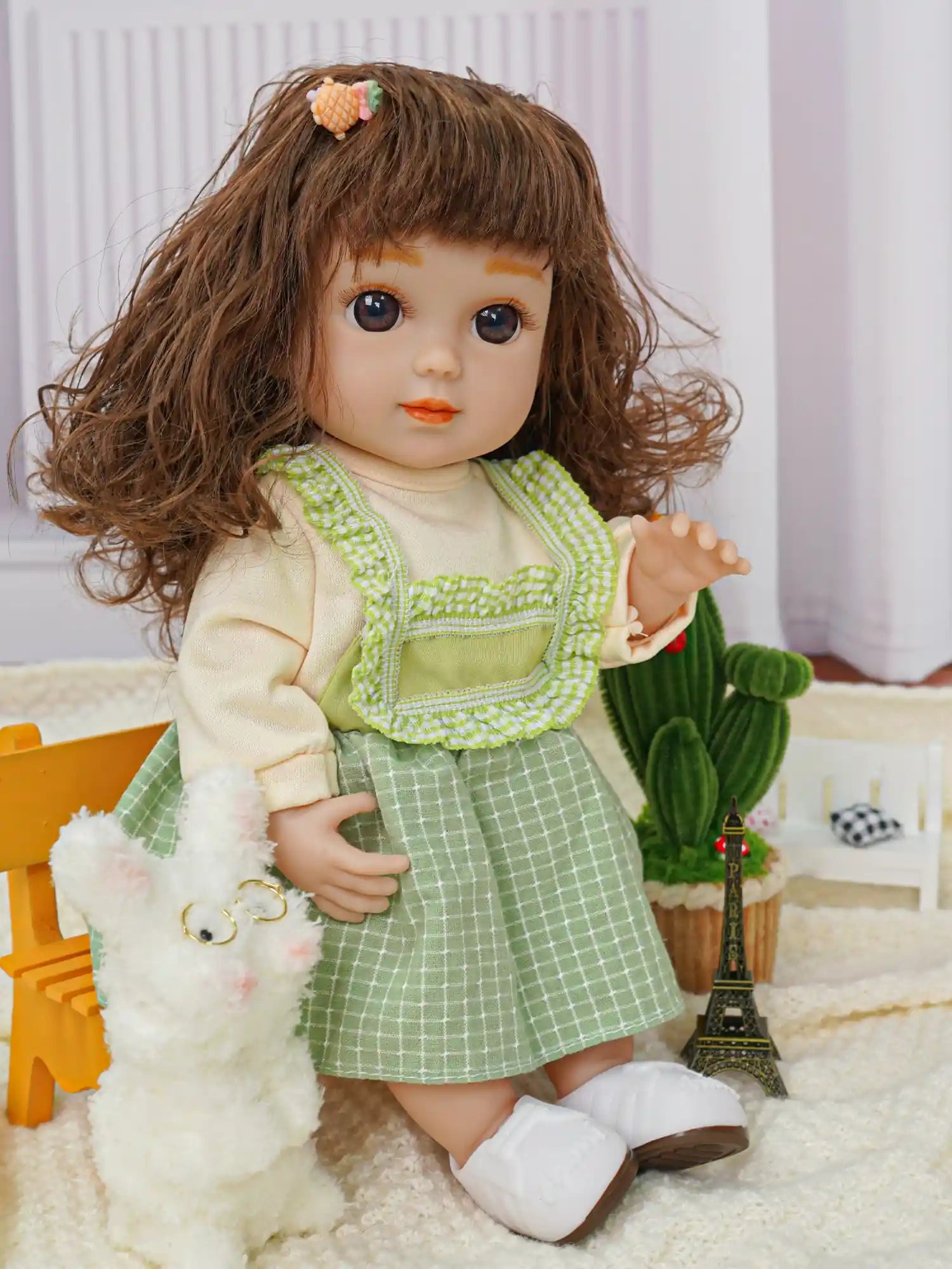 Realistic doll with layered clothing, next to quirky plush dogs and a decorative cactus.
