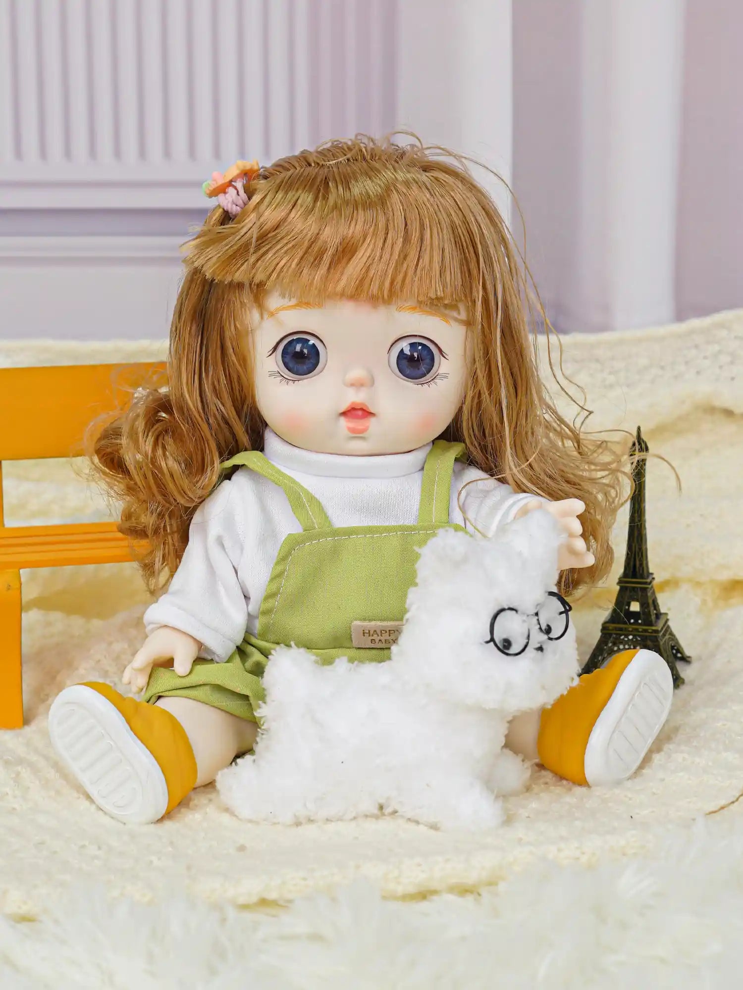 Child's play doll in a playful stance wearing overalls labeled "HAPPY BABY," with a whimsical fuzzy toy.