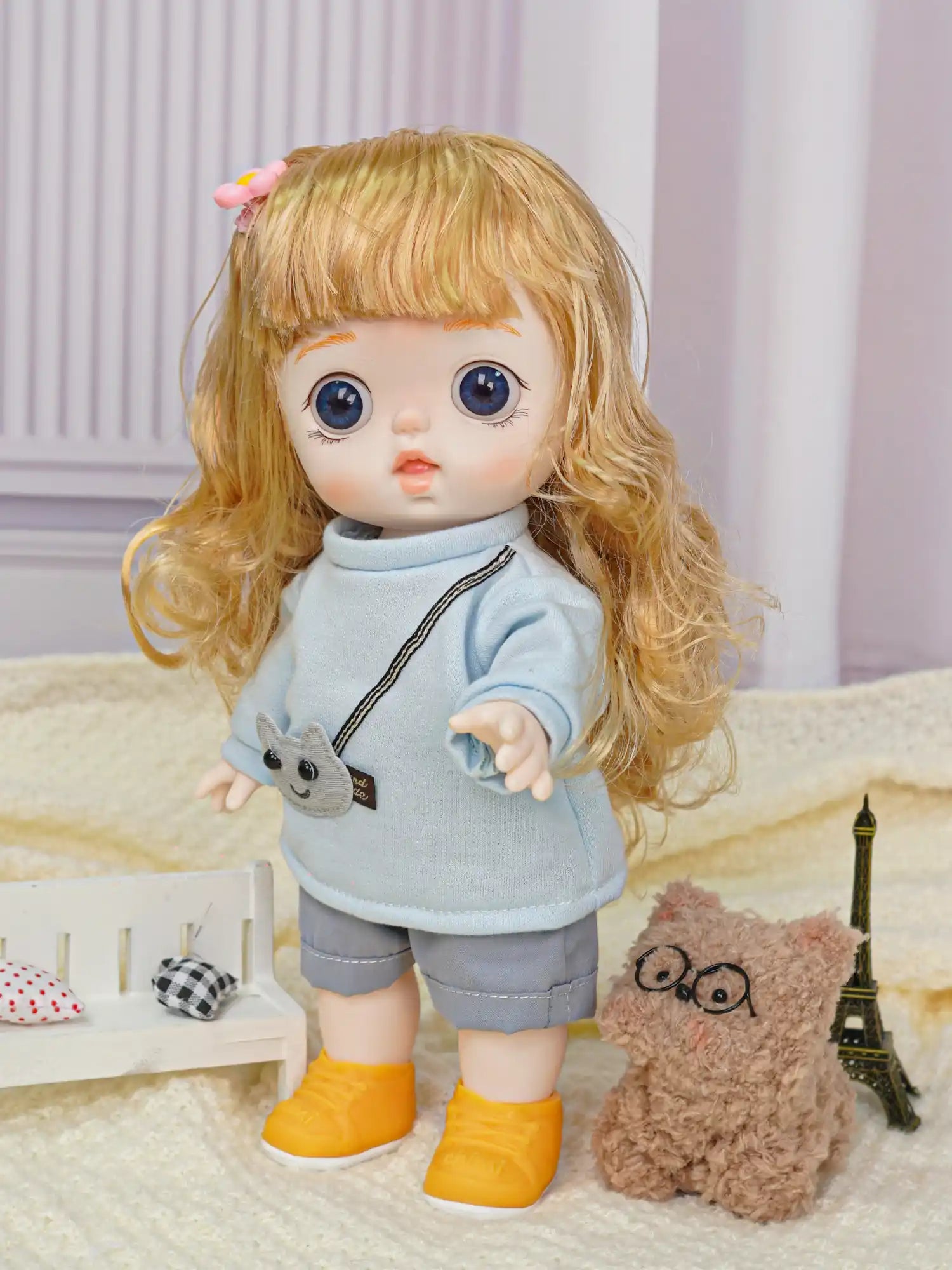 Curious-eyed doll with a cute outfit, featuring an animal pouch, next to a fuzzy toy with glasses in a modeled playroom.