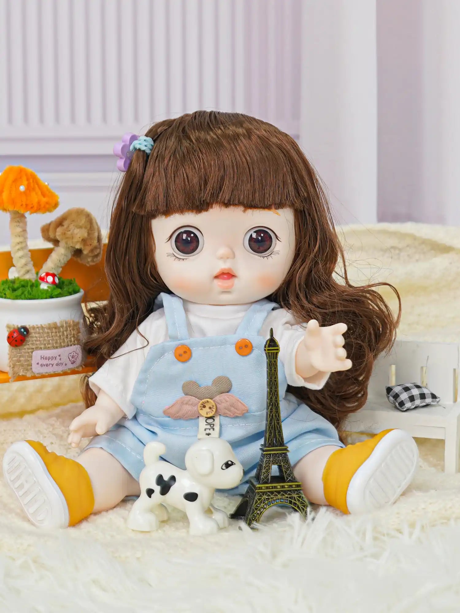 A charming doll in a white blouse and soft blue dungarees decorated with a plush bear, near a model of the Eiffel Tower.