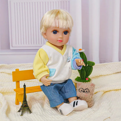 Blonde doll with blue eyes, yellow cardigan, and denim pants, seated by a toy Eiffel Tower.