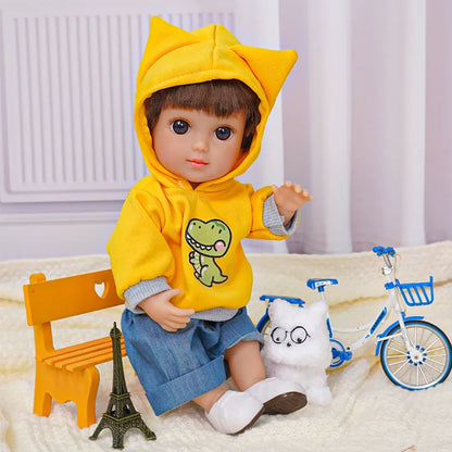 Seated doll with playful eyes, wearing a hoodie and jeans, next to a stuffed dog with glasses.