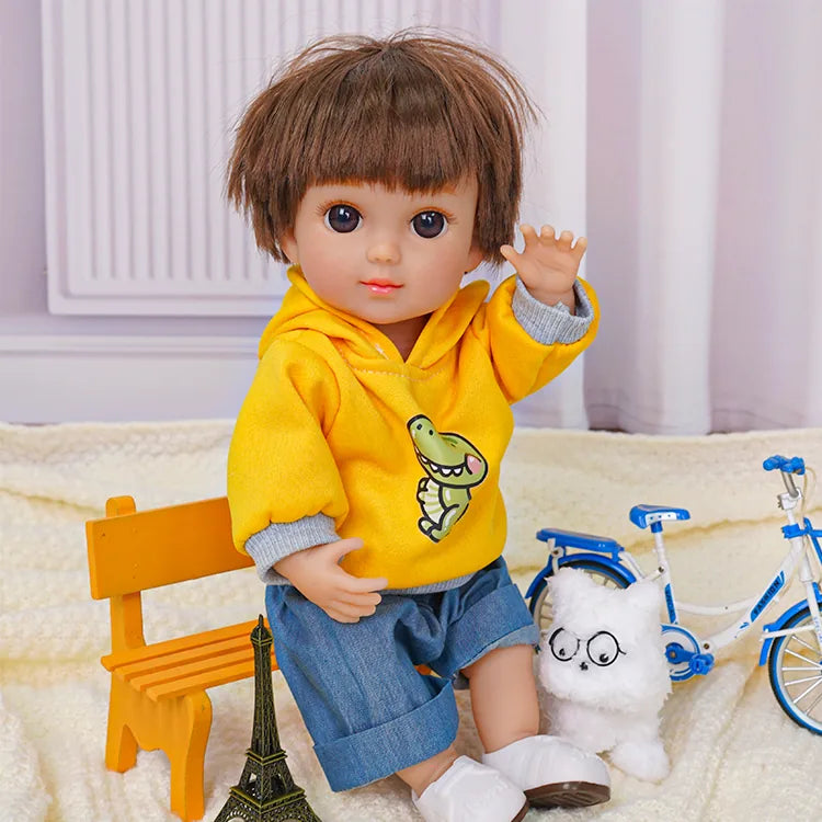 Doll with a short haircut, dressed in a sunny yellow sweatshirt, beside a white toy dog and bike.