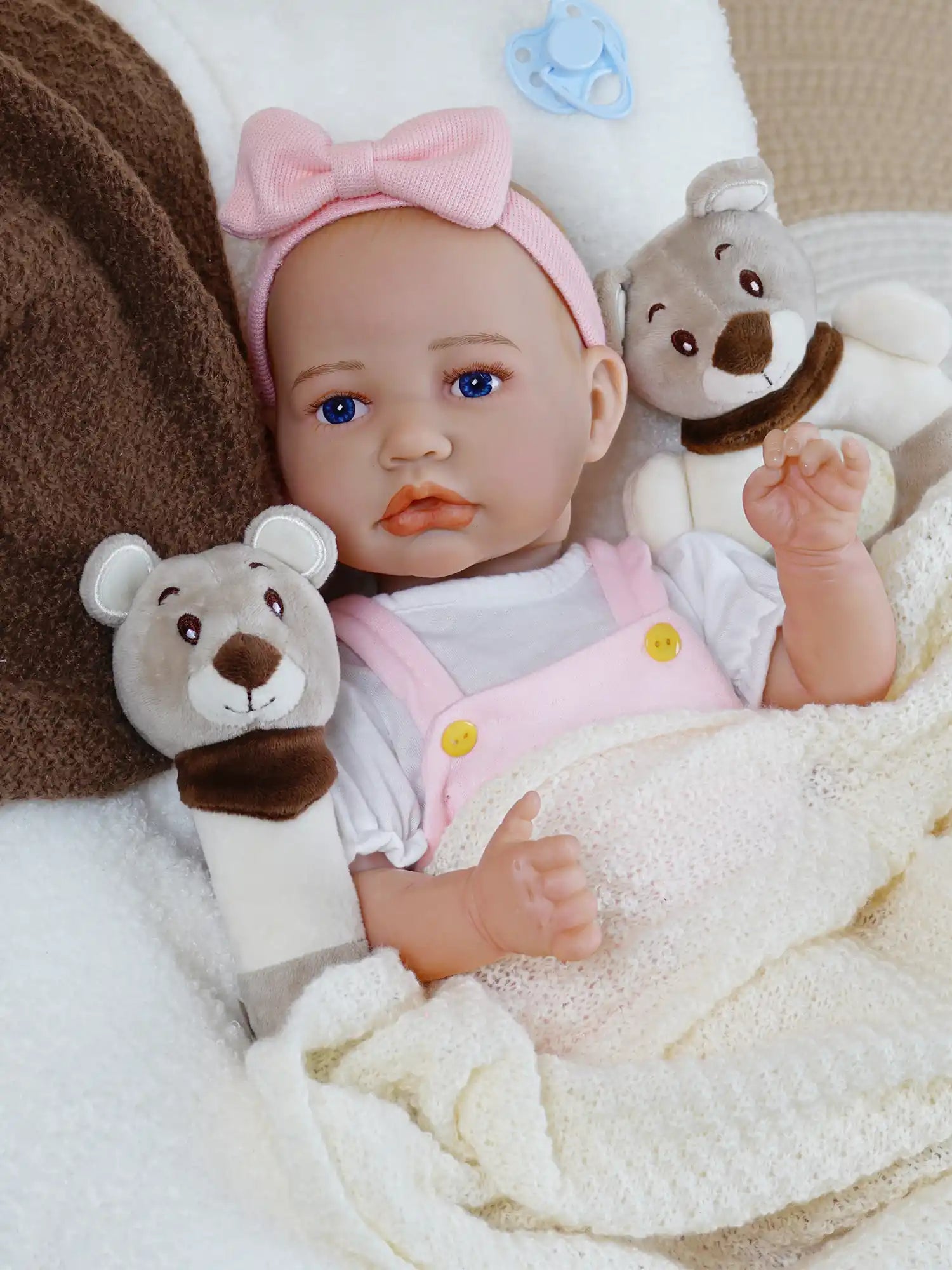 Lifelike doll with pink bow and plush toys.