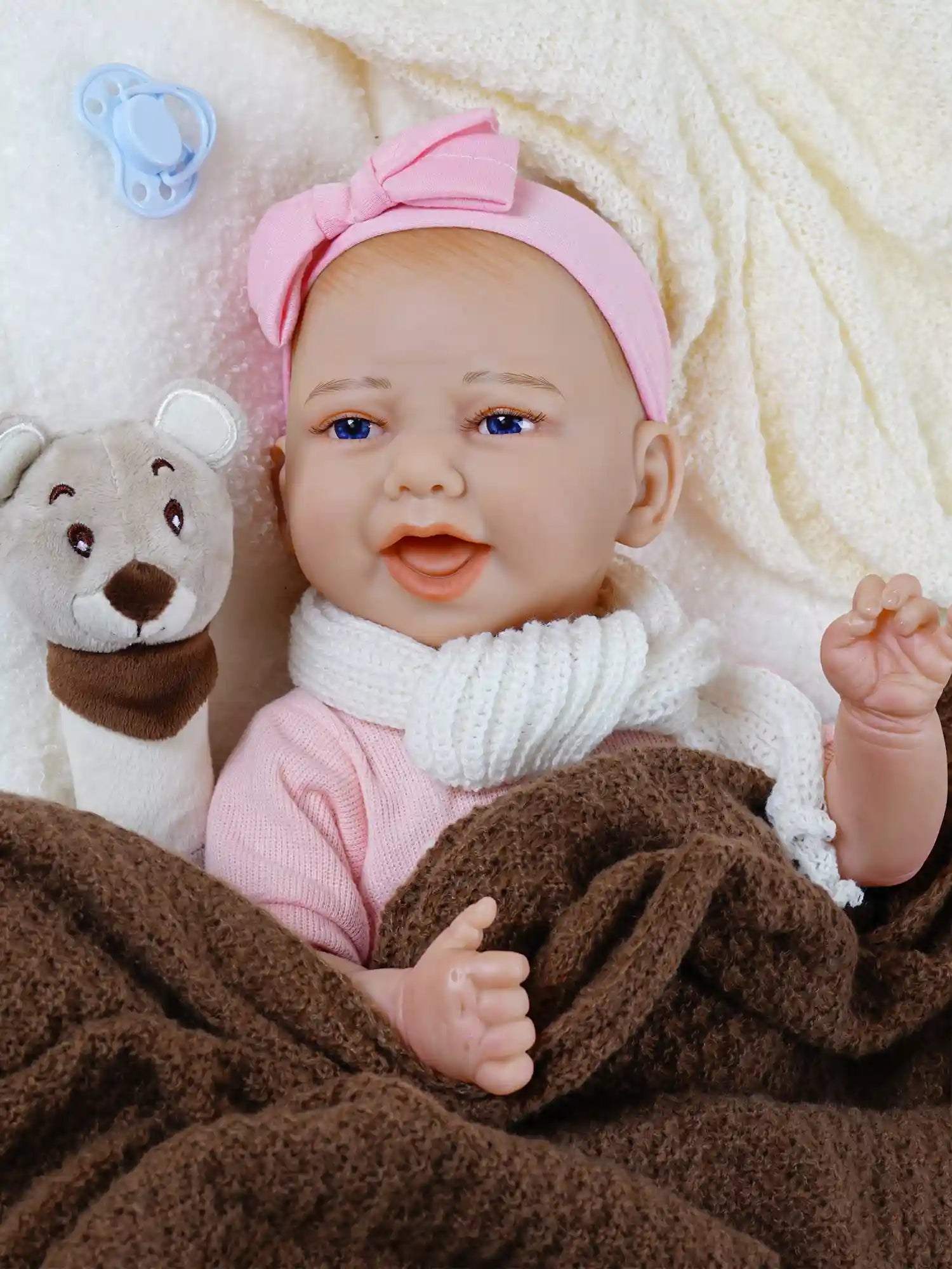 headband, cuddling with a plush bear toy, with a blue pacifier attached to its outfit