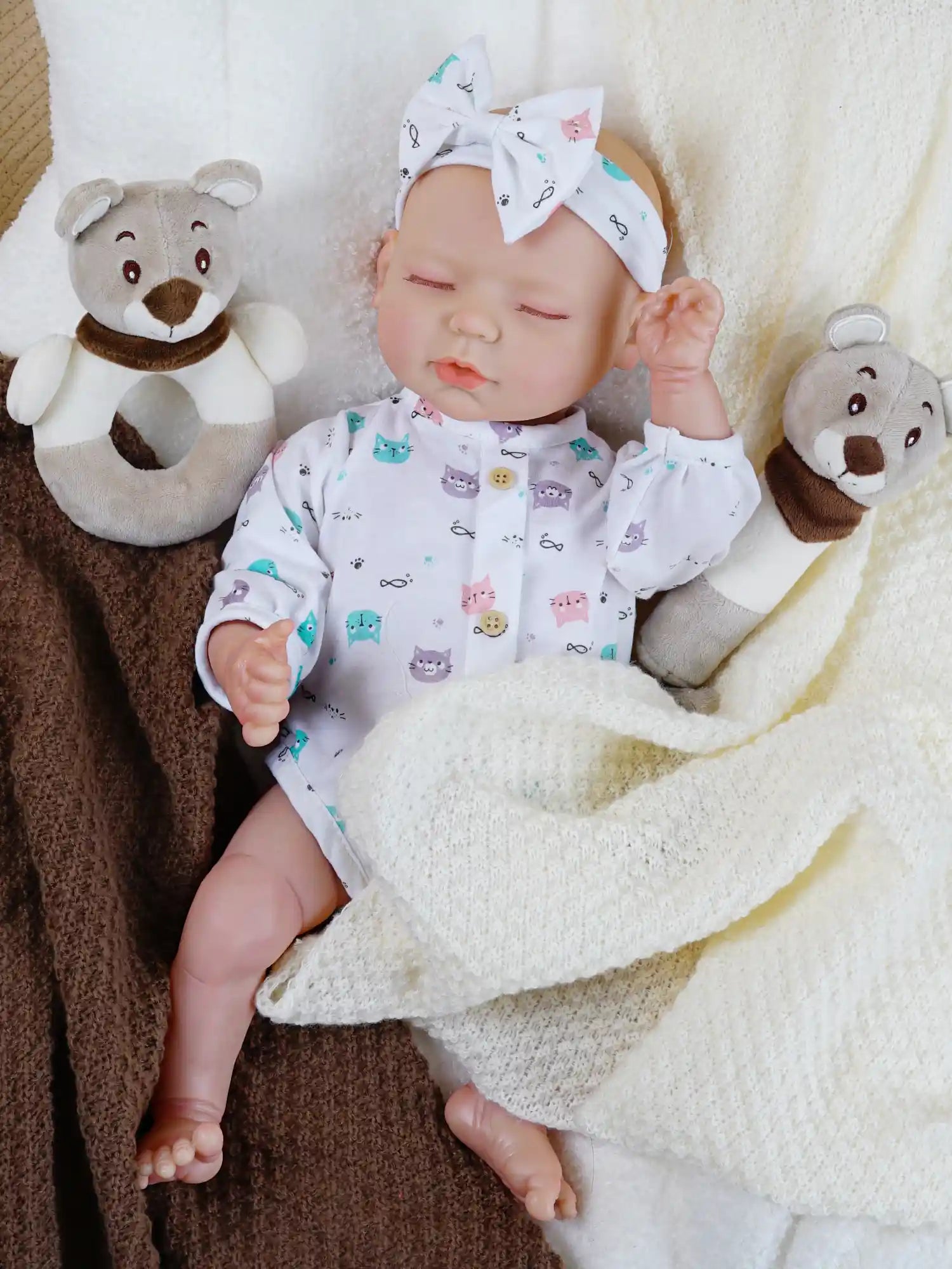 Lifelike newborn doll in animal pattern onesie with headband.