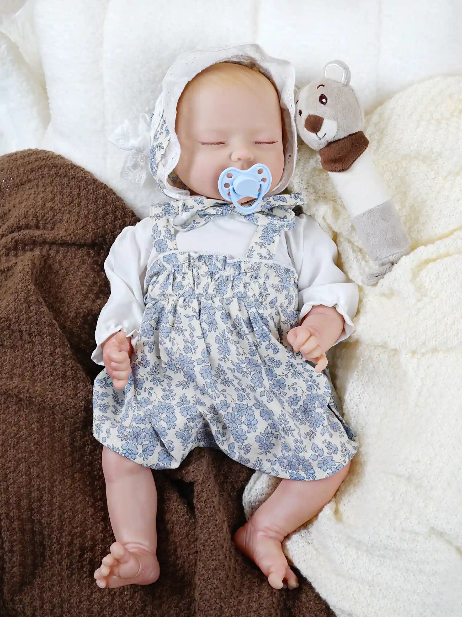 Hand-painted newborn doll with pacifier in vintage-style outfit.