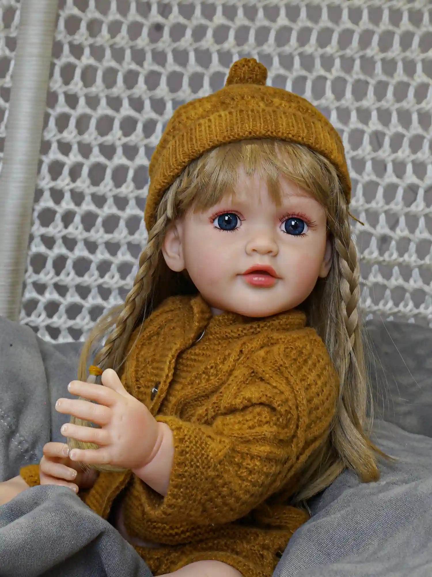 The serene expression of our reborn doll, complemented by her flowing golden locks and dressed in tranquil green, brings a peaceful presence to your home.