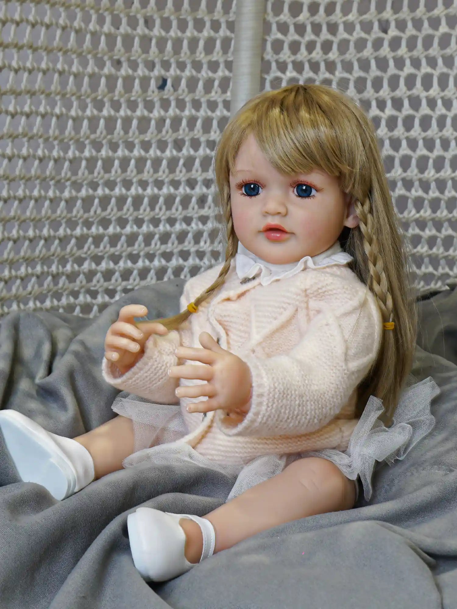 Cozy up with our reborn doll, ready for a story or a cuddle with her soft, knitted attire and inviting blue eyes.