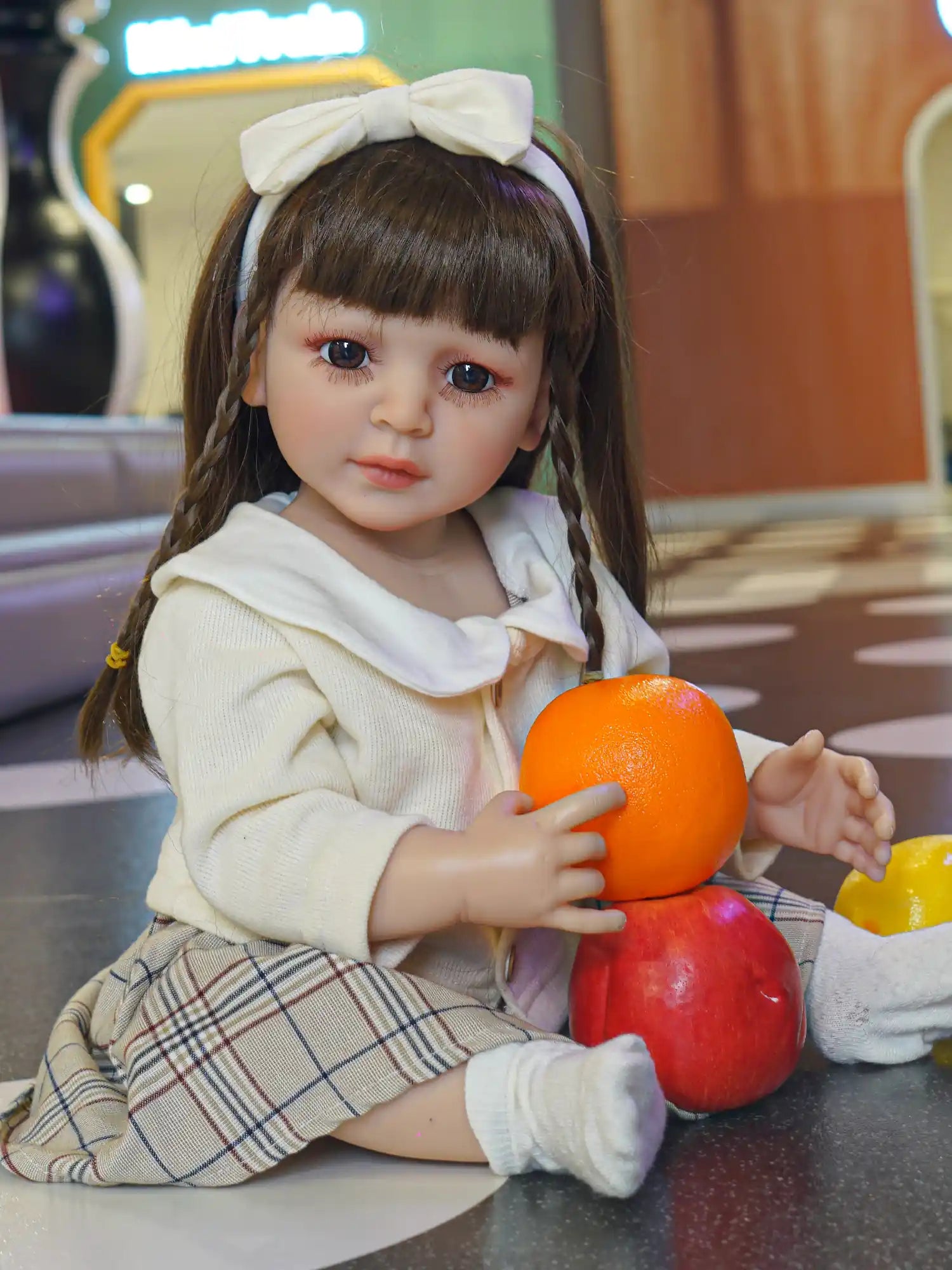 A lifelike doll with soulful eyes and braided hair, dressed in a timeless ensemble, situated in a child-friendly setting.