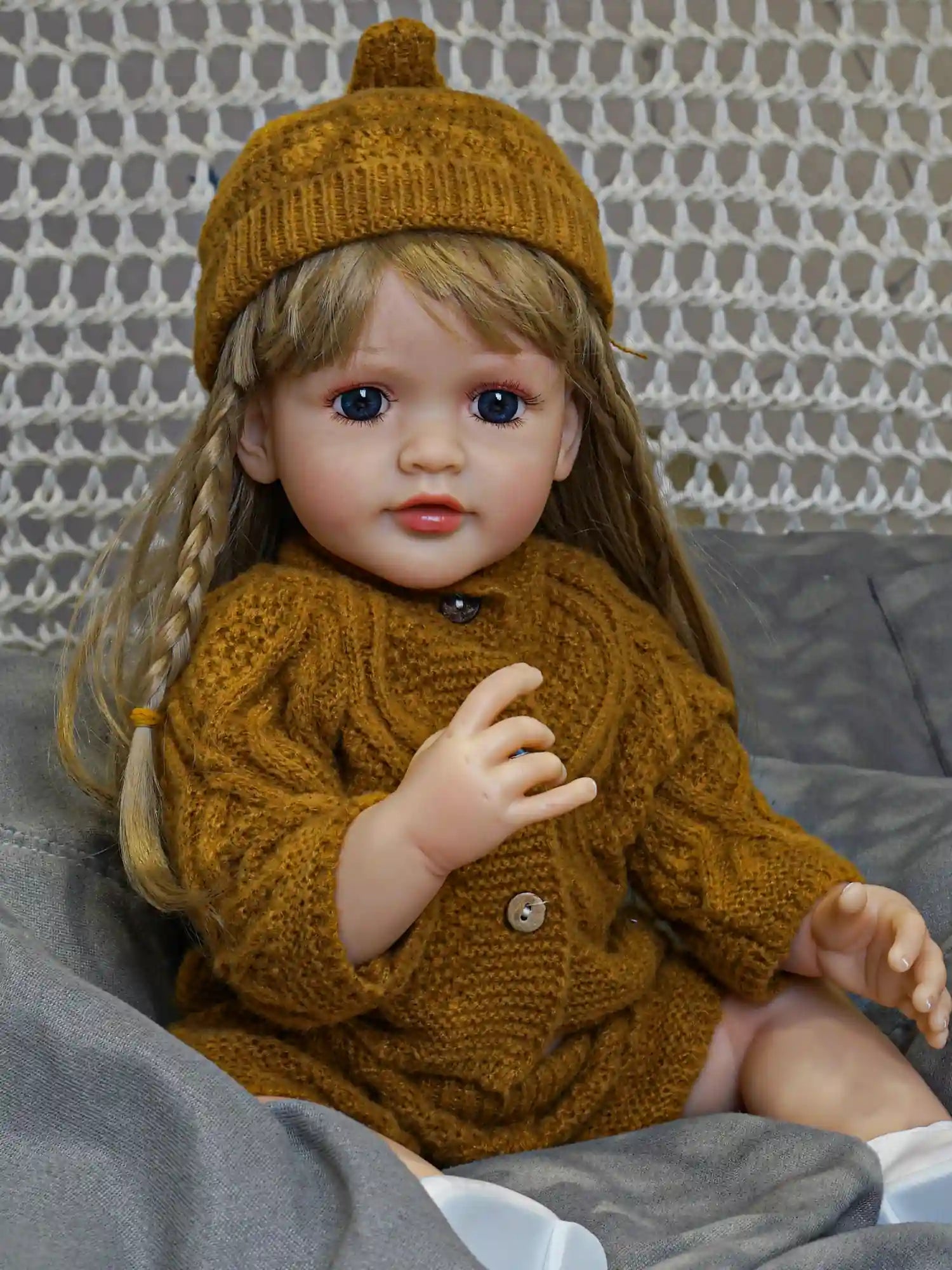 Our lovingly crafted reborn doll, with her warm blonde hair and dressed in a charming green frock, is a symbol of joy and serenity.