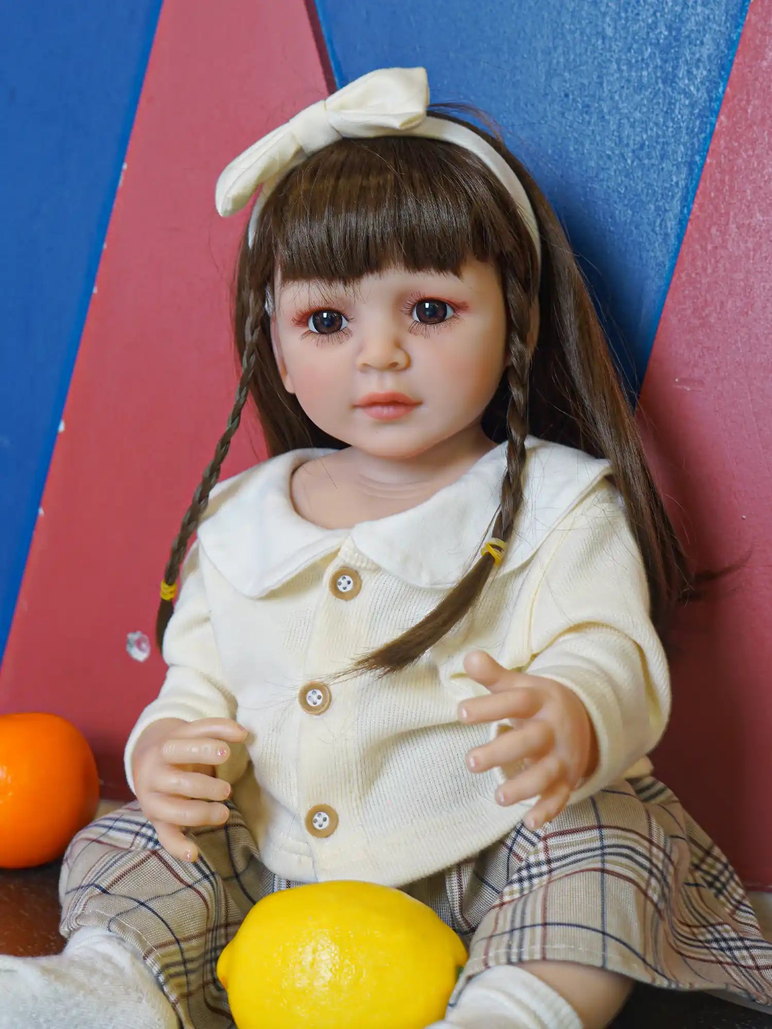 Doll in a poised sitting position, adorned with a white bow, embracing a classic schoolgirl charm.