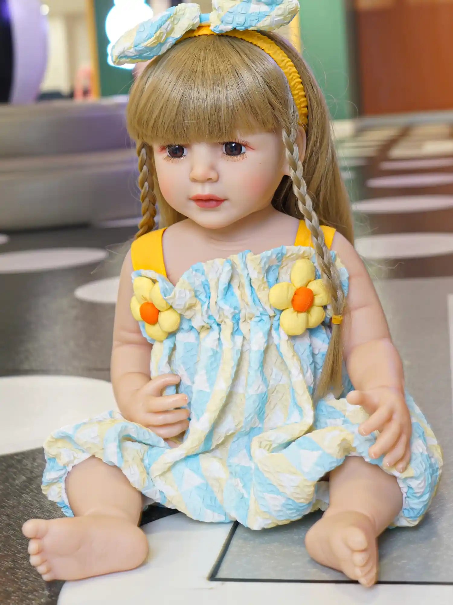 Doll with yellow hair accessories and a ruffled dress, posing with a soft gaze.