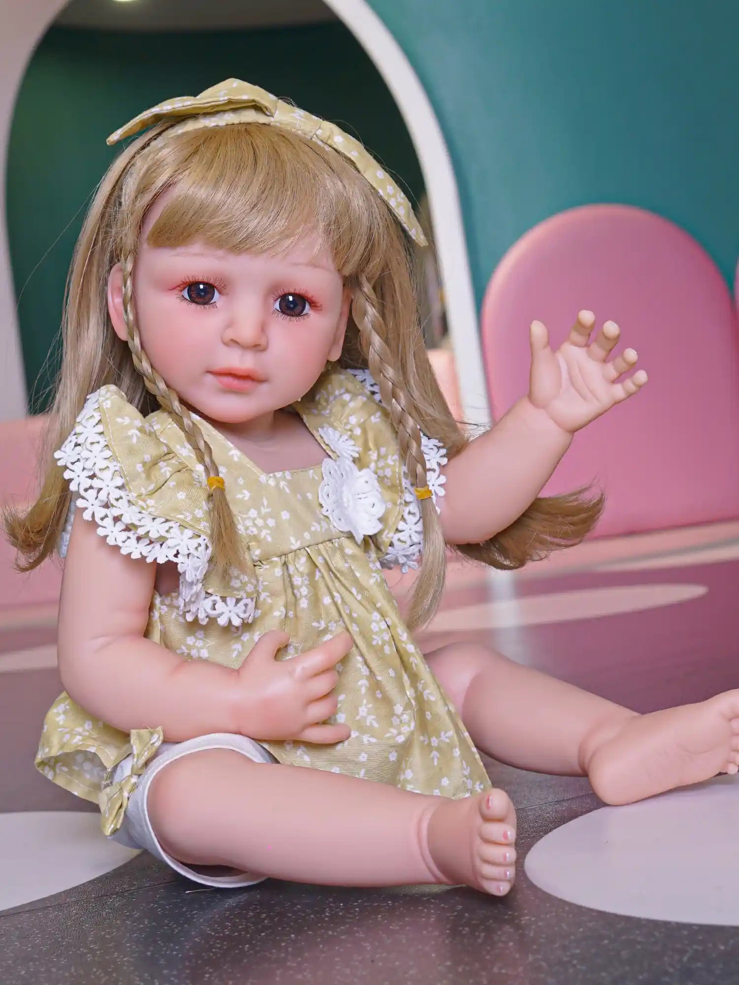 Realistic doll with braided hair, wearing a patterned dress, poised in a playful wave.