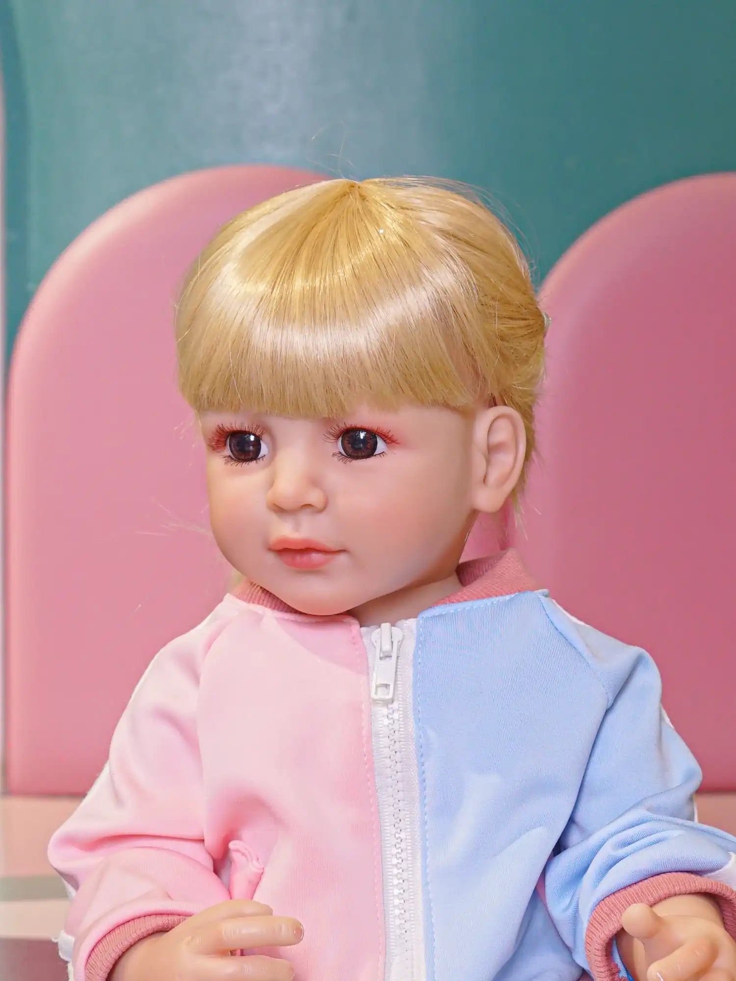 Blonde-haired doll with blue eyes, in casual pink and blue attire.