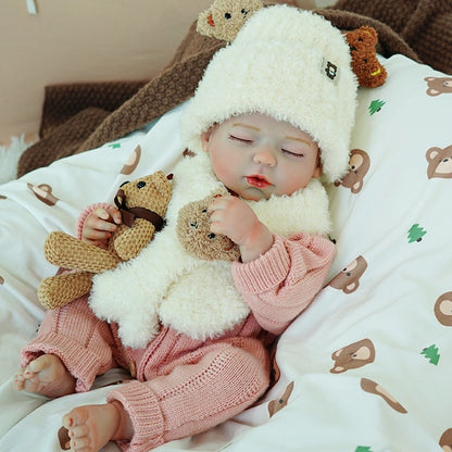 Reborn baby doll with eyes closed, snuggled next to two toy bears, wearing a cute white sheep hat.