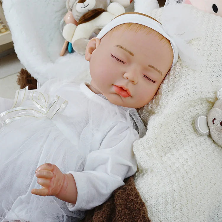 Realistic doll in white celebration outfit with bow.