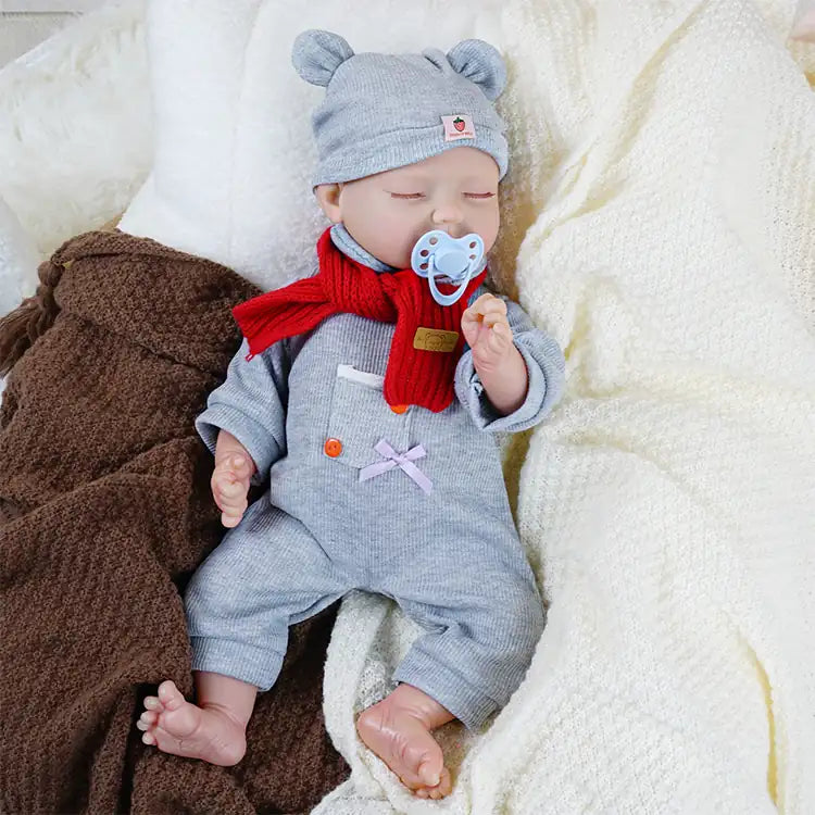 Lifelike doll in winter attire with pacifier.