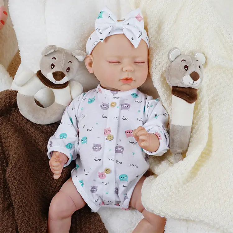 Realistic reborn baby with feeding bottle in printed sleepwear.