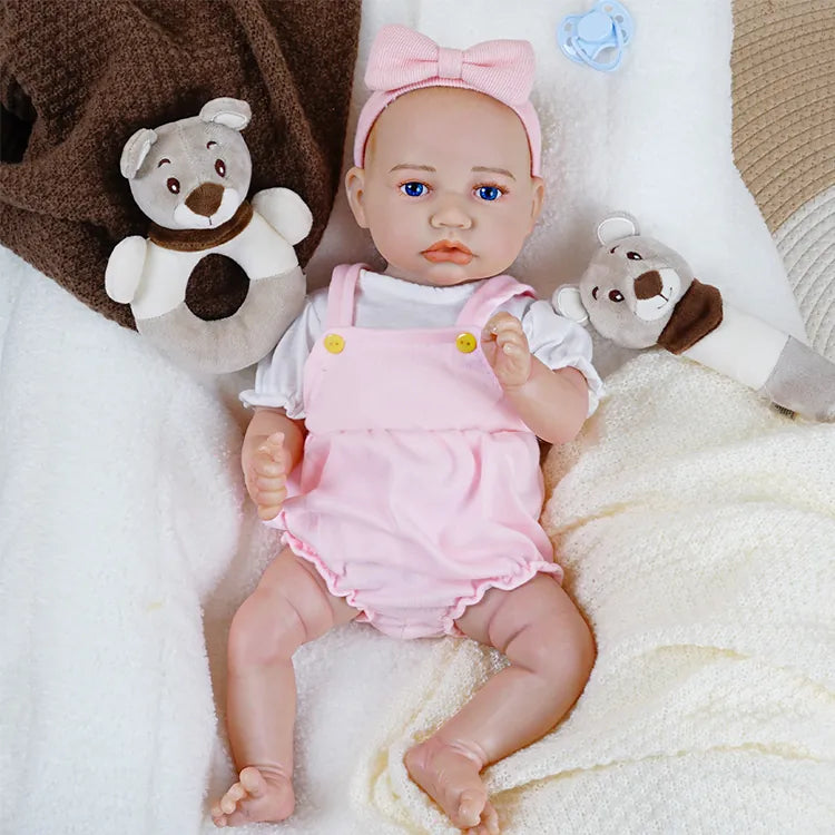 Reborn doll in pink with teddy bear and pacifier.