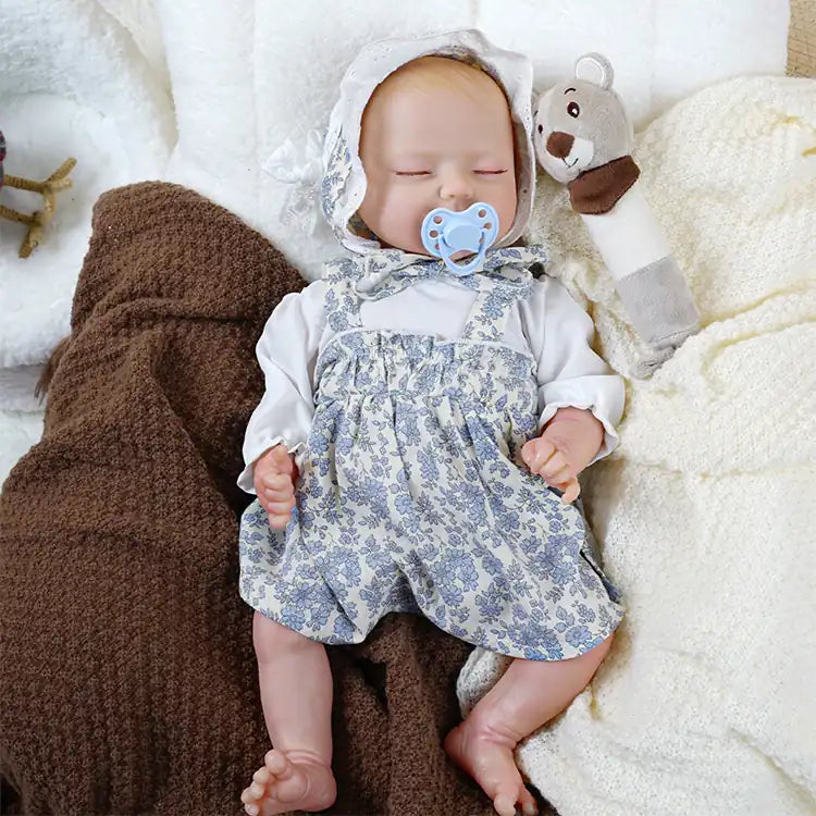 High-detail reborn baby girl in classic blue floral romper.