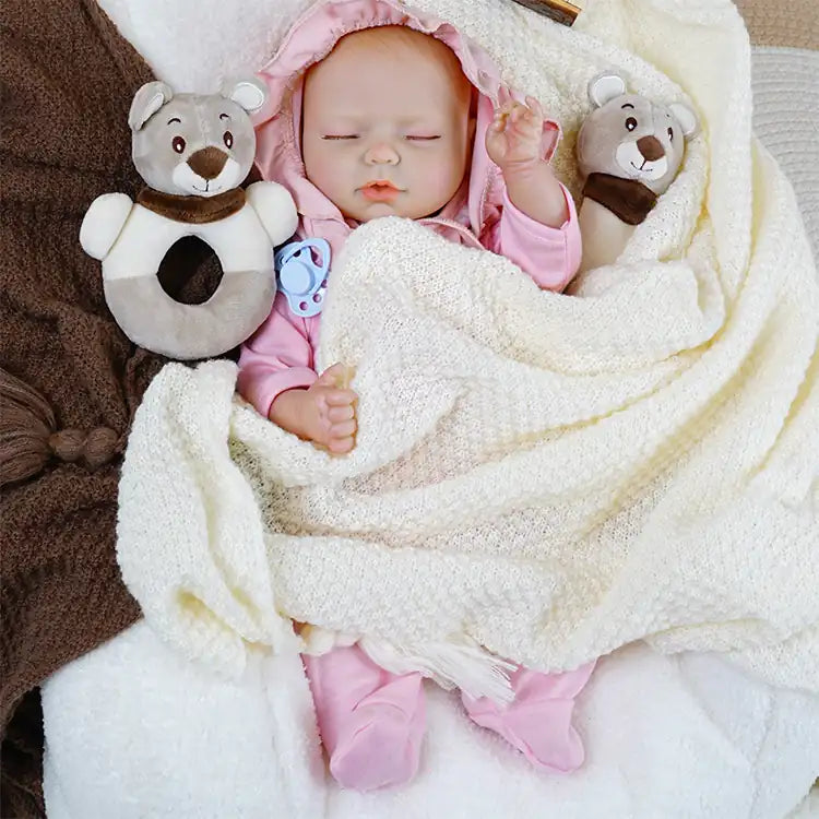 Realistic baby doll in cuddly pink sleepwear ready for nap.