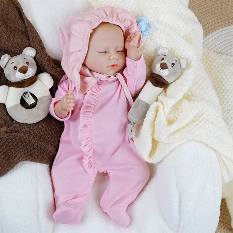 Reborn doll in cozy pink hooded jumpsuit with bottle.