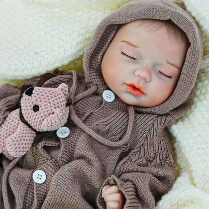 A reborn baby doll lying on its side, cuddling a pink teddy bear, peacefully sleeping.