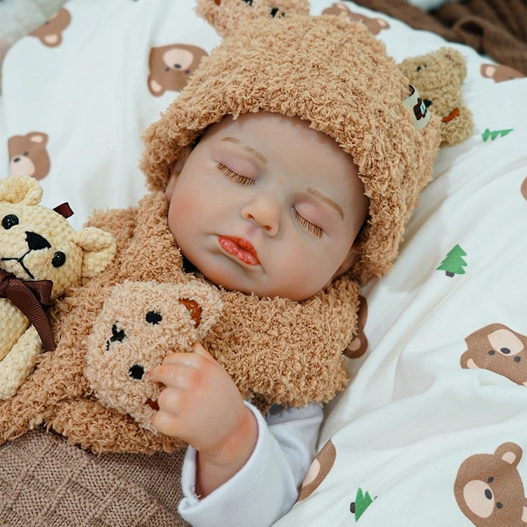 Close-up of reborn baby doll holding a soft teddy bear.