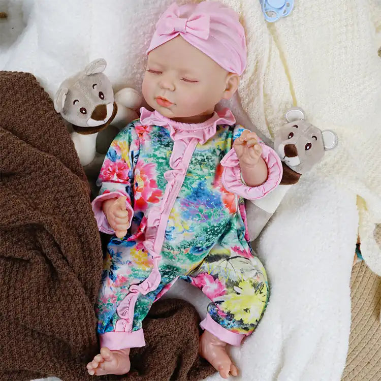 Colorful floral jumpsuit on lifelike reborn baby doll.