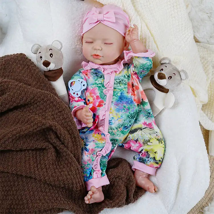Reborn doll with vibrant flower print and pink headband.