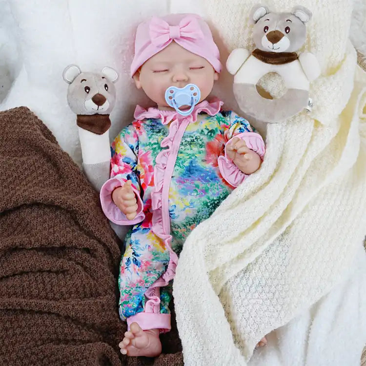 Sleeping baby doll in vivid floral outfit with soft accessories.