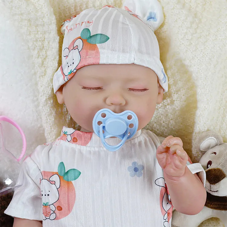 Reborn baby doll in fruity patterned romper and matching hat.