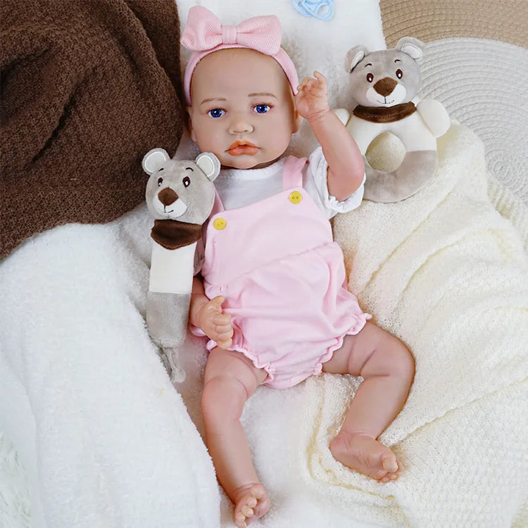 Realistic baby doll in pink with a pacifier.