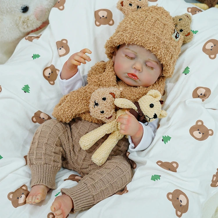 Reborn baby doll resting peacefully, cuddling a teddy bear.