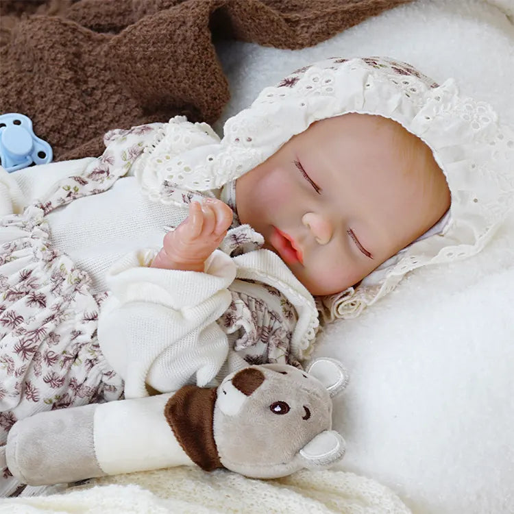 Collectible newborn doll dressed in delicate floral romper.