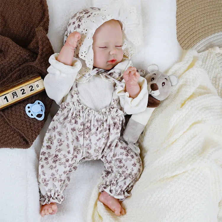 Soft-touch vinyl reborn doll with realistic sleeping pose.